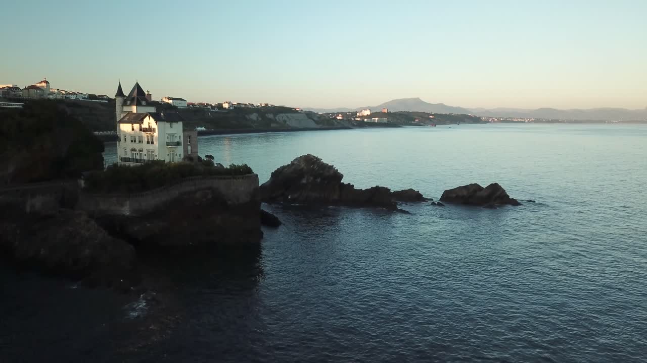 Drone che sorvola una splendida casa di lusso arroccata sulla spiaggia di Biarritz al tramonto, Francia.