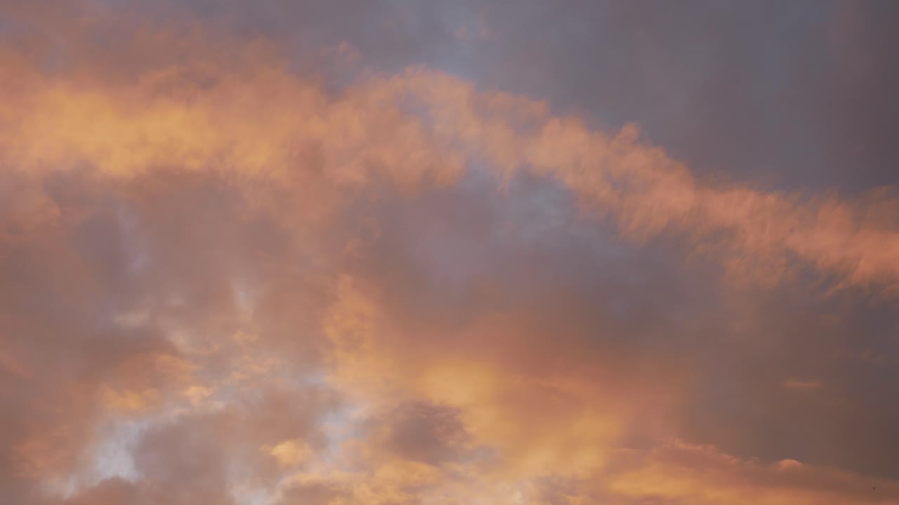 Time passing - dark clouds lit by orange sunset, time lapse view