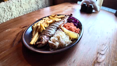 trucha al horno en un plato con mezcla de limón y ensalada