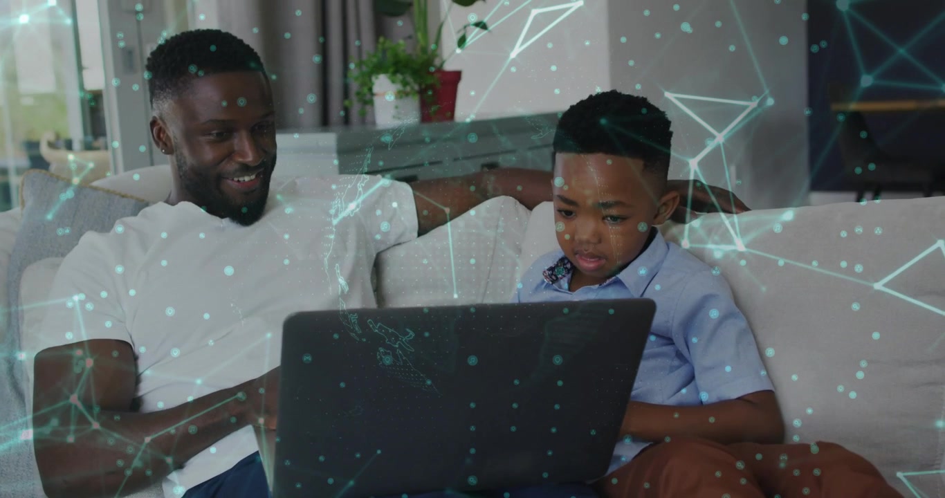 Father guiding son after boy opening laptop on couch while network overlaying scene showing code