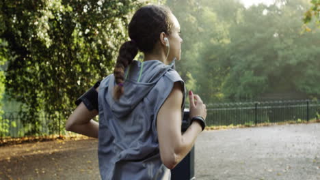 Mujer-Corredora-Corriendo-En-El-Parque-Haciendo-Ejercicio-Al-Aire-Libre-Rastreador-De-Ejercicios-Tecnología-Portátil