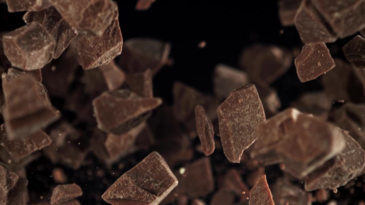 Movimento rallentato di pezzi di cioccolato che volano e cadono