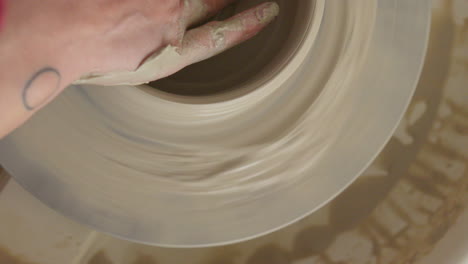 potter crafts a bowl on a throwing wheel delicately