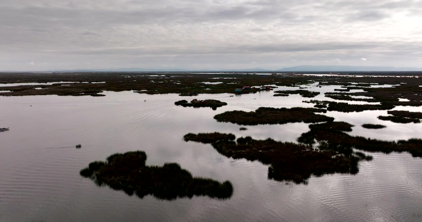 Vista da drone di isole tradizionali costruite su acque calme del lago Titicaca sotto un cielo nuvoloso a Puno, Perù. Vista aerea, spazio per il testo.