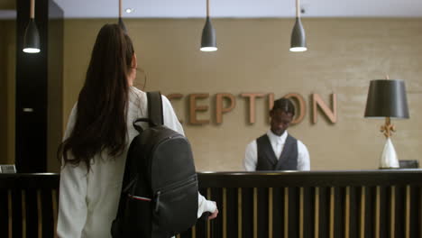 una mujer joven registrándose en el hotel.