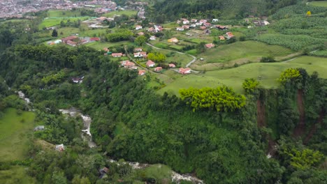 A-flyover-a-river-and-a-small-town-in-Colombia,-called-Jardin