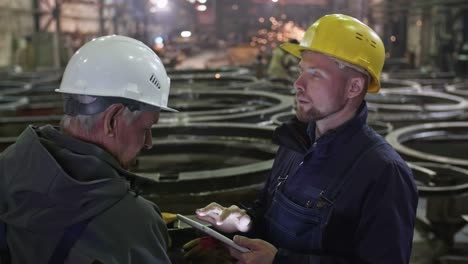 engineer showing metal fabrication facility to supervisor