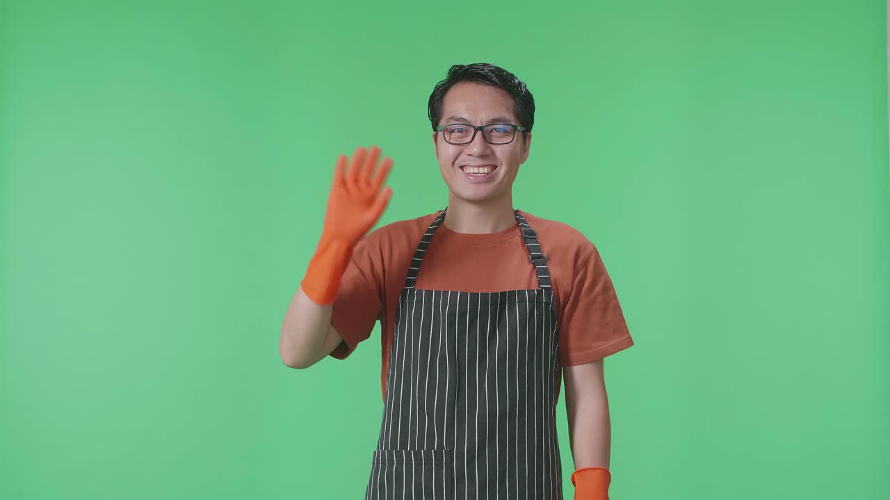 앞옷과 오렌지색 장갑을 입은 남자가 흔들고 있다