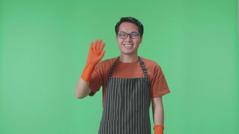 hombre con delantal y guantes naranjas agitando