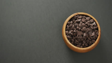 video de vista aérea de un cuenco de madera de chispas de chocolate sobre un fondo gris