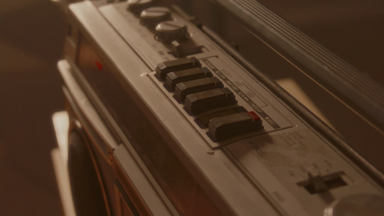 Hand Inserting Audio Cassette and Pressing Play Button on Vintage Boombox