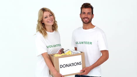 two volunteers holding a donations box