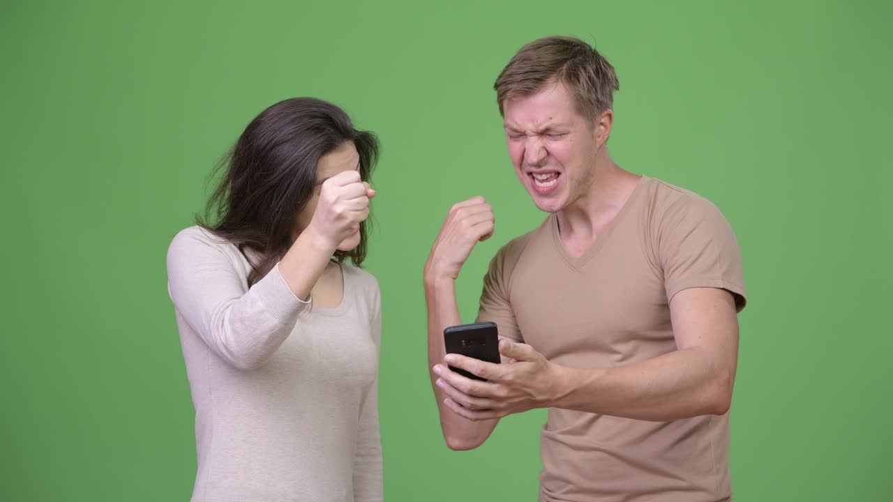 젊은 행복 한 부부 는 함께 흥분 한 것 을 보면서 전화 를 사용 한다