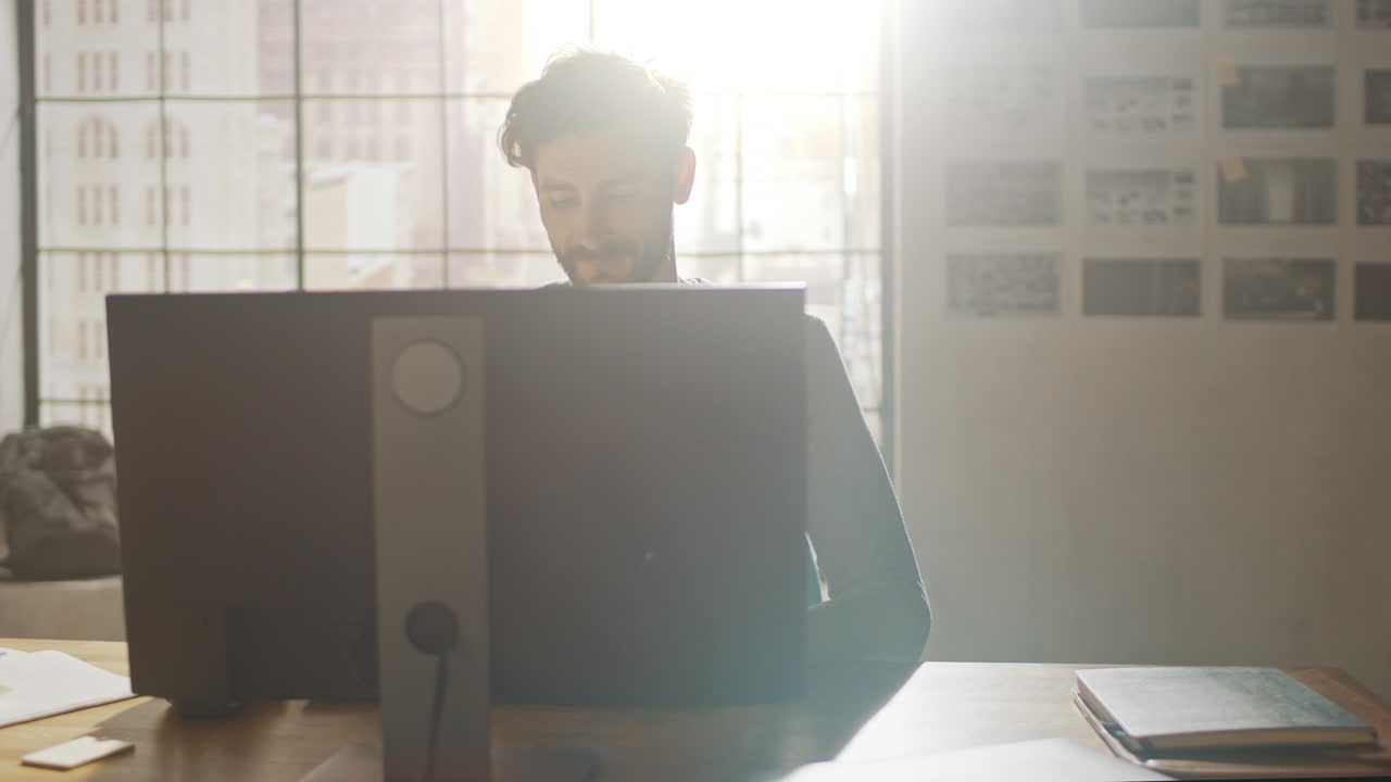 크리에이티브 디자이너는 사무실 스튜디오에서 책상에 앉아 스마트폰 소프트웨어 개발 애플리케이션을 화면에 고 있는 데스크 컴퓨터에서 작업하고 있습니다.