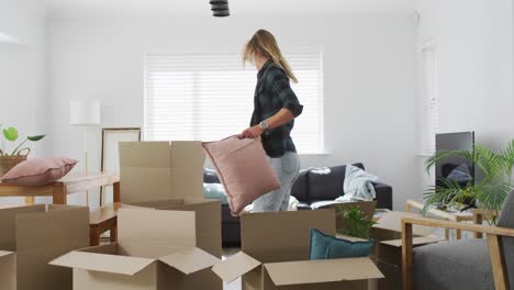 pareja feliz de mujeres diversas hablando y sosteniendo cajas durante la mudanza a casa