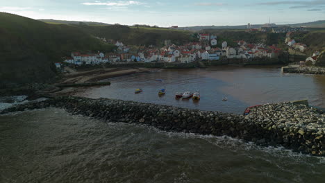 pullback establishing aerial shot of staithes coastal village uk