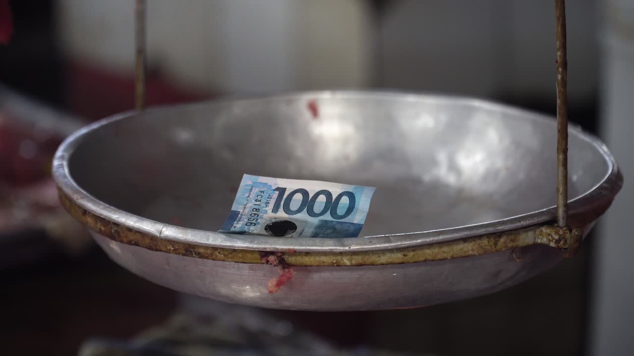 dinero en la balanza en el mercado callejero