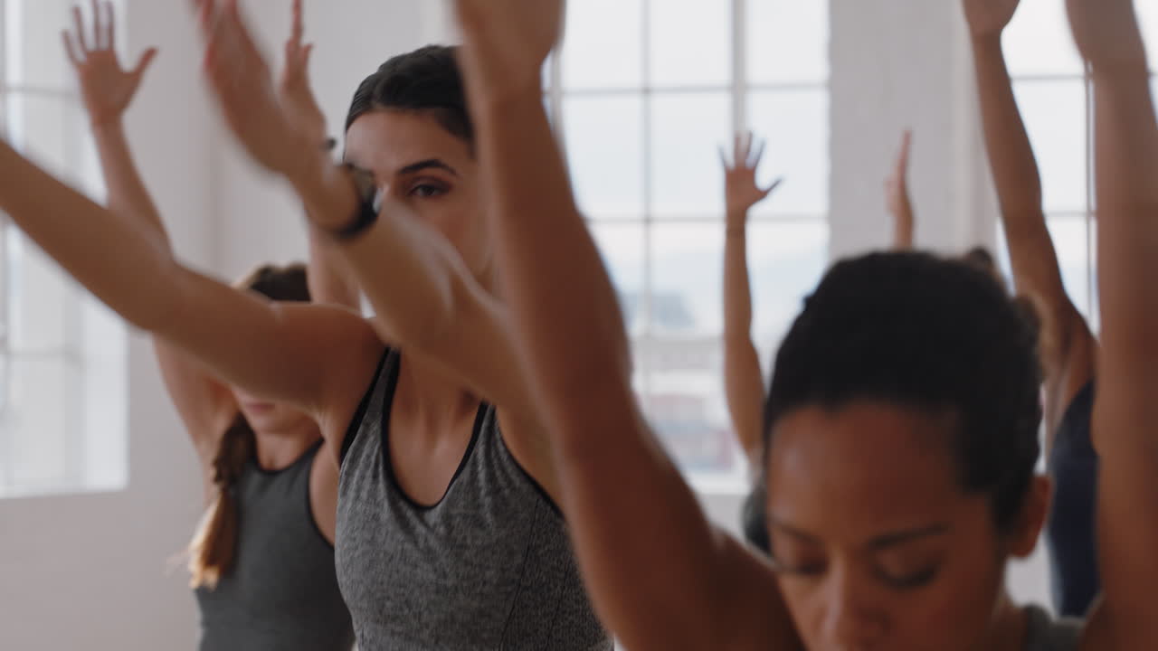 healthy caucasian yoga woman practicing warrior pose meditation with group of multiracial women enjoying fitness lifestyle exercising flexible body in workout studio