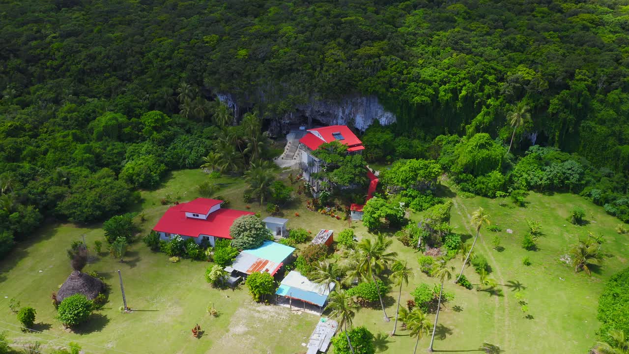 capturada por un dron, aparece una casa encaramada en un afloramiento rocoso costero en la isla de lifou