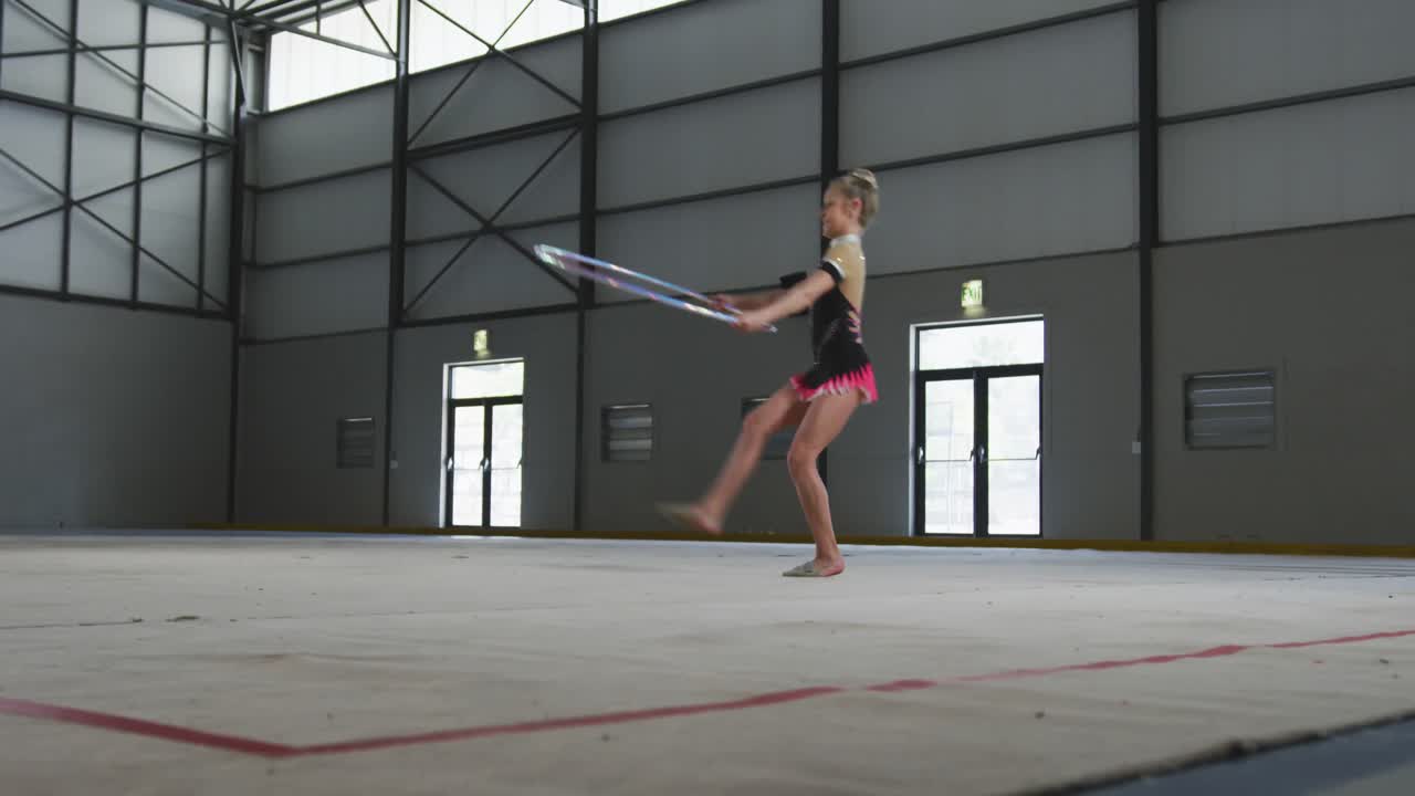십대 여성 체조 선수 가 스포츠 홀 에서 공연 하고 있다