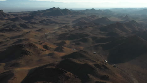 rotating cinematic drone shot of a caravanning fleet of cars through charyn canyon, kazakhstan