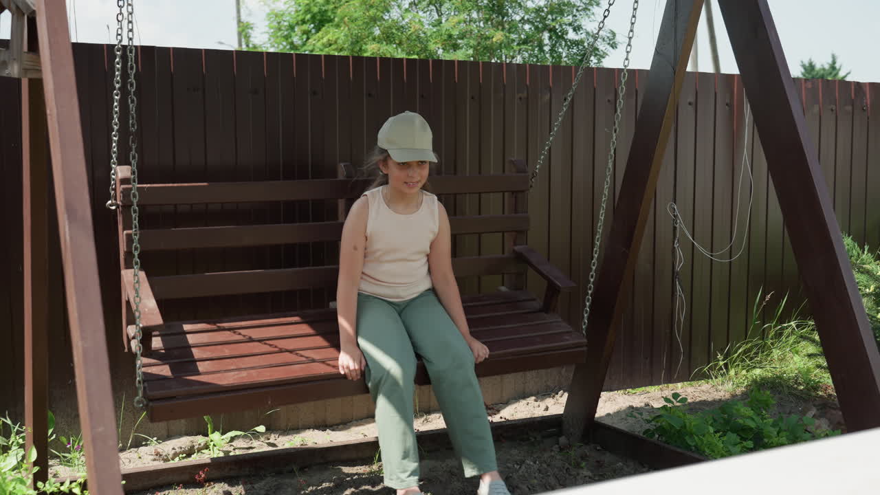 Calm Youthful Scene, Quiet Young Lady Enjoying Park Swing, Tranquil Female Child Seated Calmly In Park Environment, Serene Young Girl Lost In Thought While Swinging Peacefully During Summer