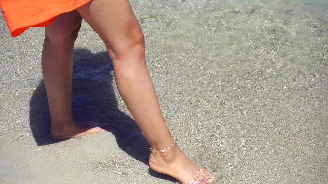 해변 4k에서 은 모래를 고 있는 젊은 여성