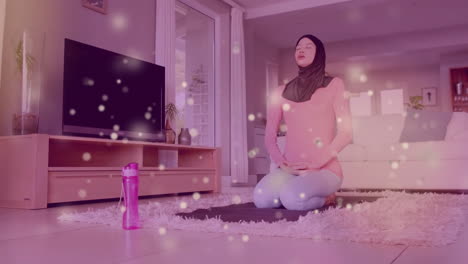 Animation-of-light-spots-over-biracial-woman-in-hijab-practicing-yoga