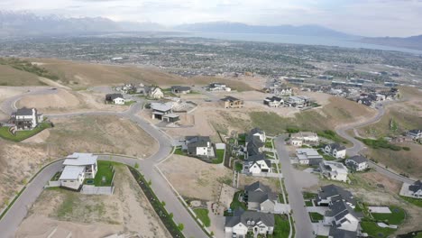 aerial view of large homes on a mountainside of a new development neighborhood in traverse mountain, lehi utah, orbiting shot