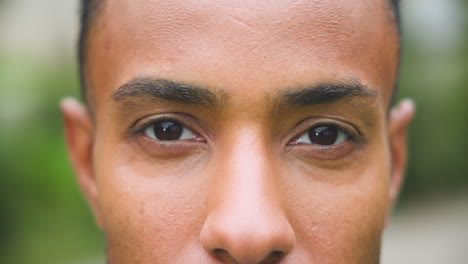outdoors, man focusing intently with close-up of eyes in natural light
