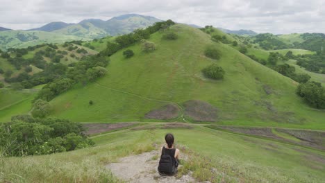 Joven-Excursionista-Disfrutando-De-Las-Vistas-De-Las-Verdes-Colinas-De-California