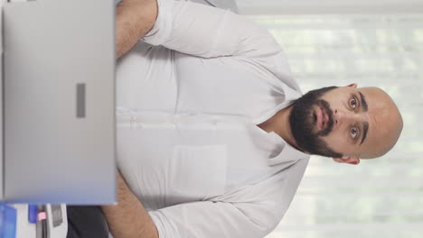 Vertical-video-of-Home-office-worker-man-confused-and-thoughtful.