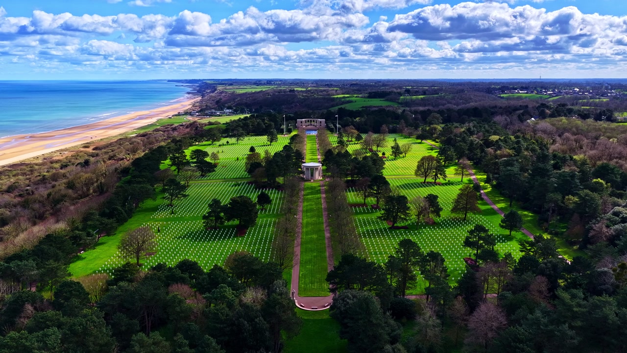 Aerial View Of Normandy American Cemetery In Colleville-sur-Mer, France, Overlooking Omaha Beach And Atlantic Ocean. timelapse