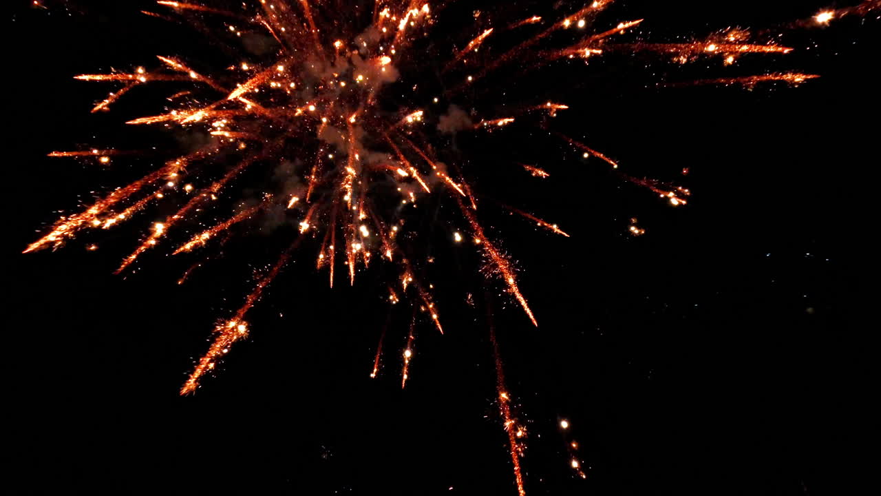 Slow motion fireworks exploding in dark sky, dramatic and vivid visuals