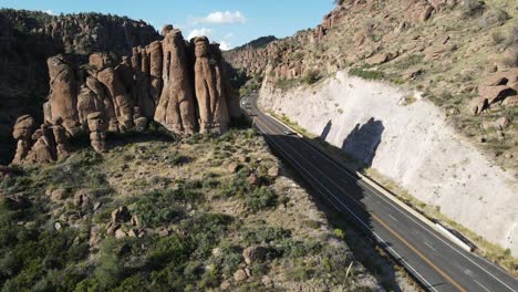 Toma-Aérea-Ascendente-Revelada-De-Una-Carretera-Rodeada-De-Rocas-Gigantes