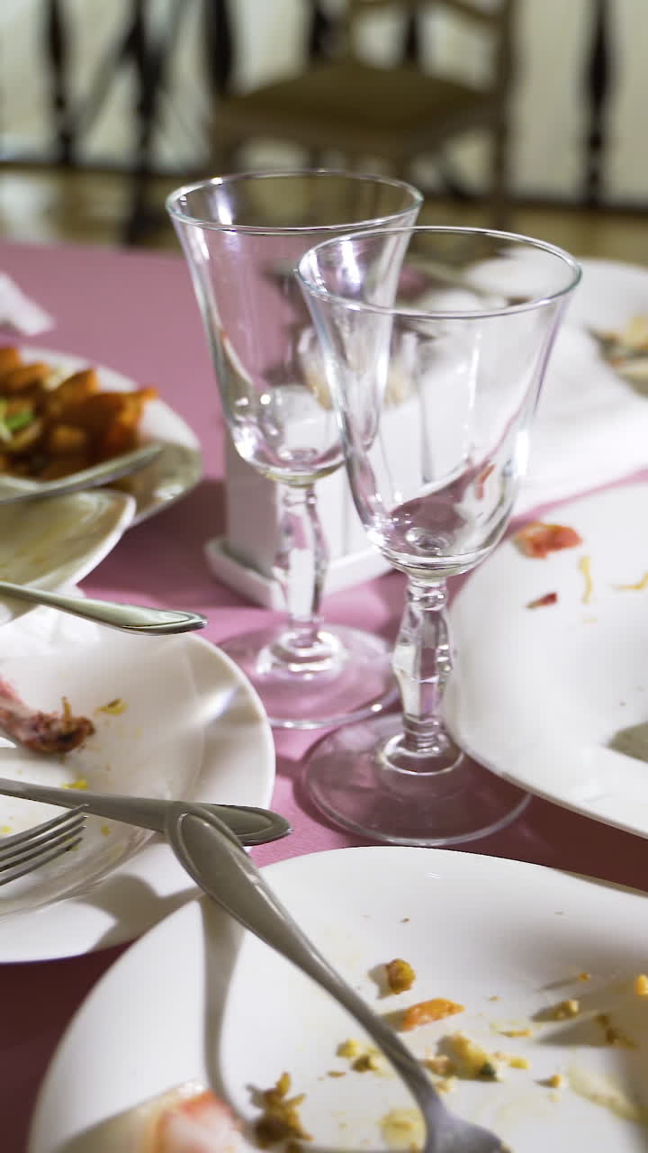 remnants of meat dishes and snacks are on the festive table after the feast. Camera motion to the right. Blurred background Vertical video