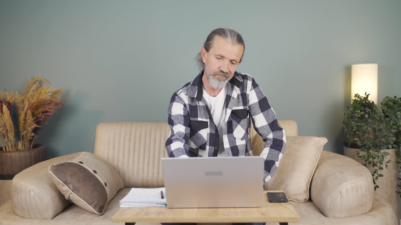 el hombre que mira la computadora portátil está desmotivado y aburrido.