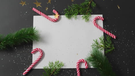 christmas decorations with candy canes and greenery over festive animation background