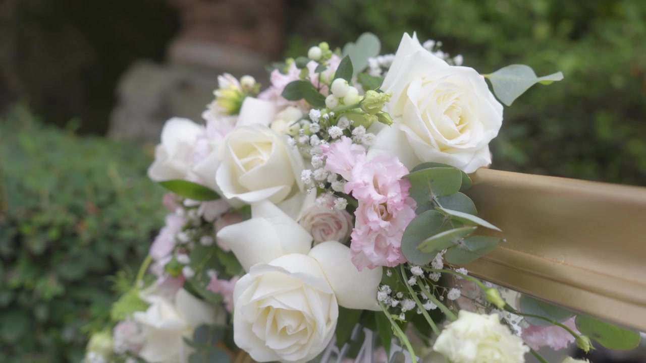 En smuk buket af hvide, cremefarvede og lyserøde blomster som bryllupsdekoration.