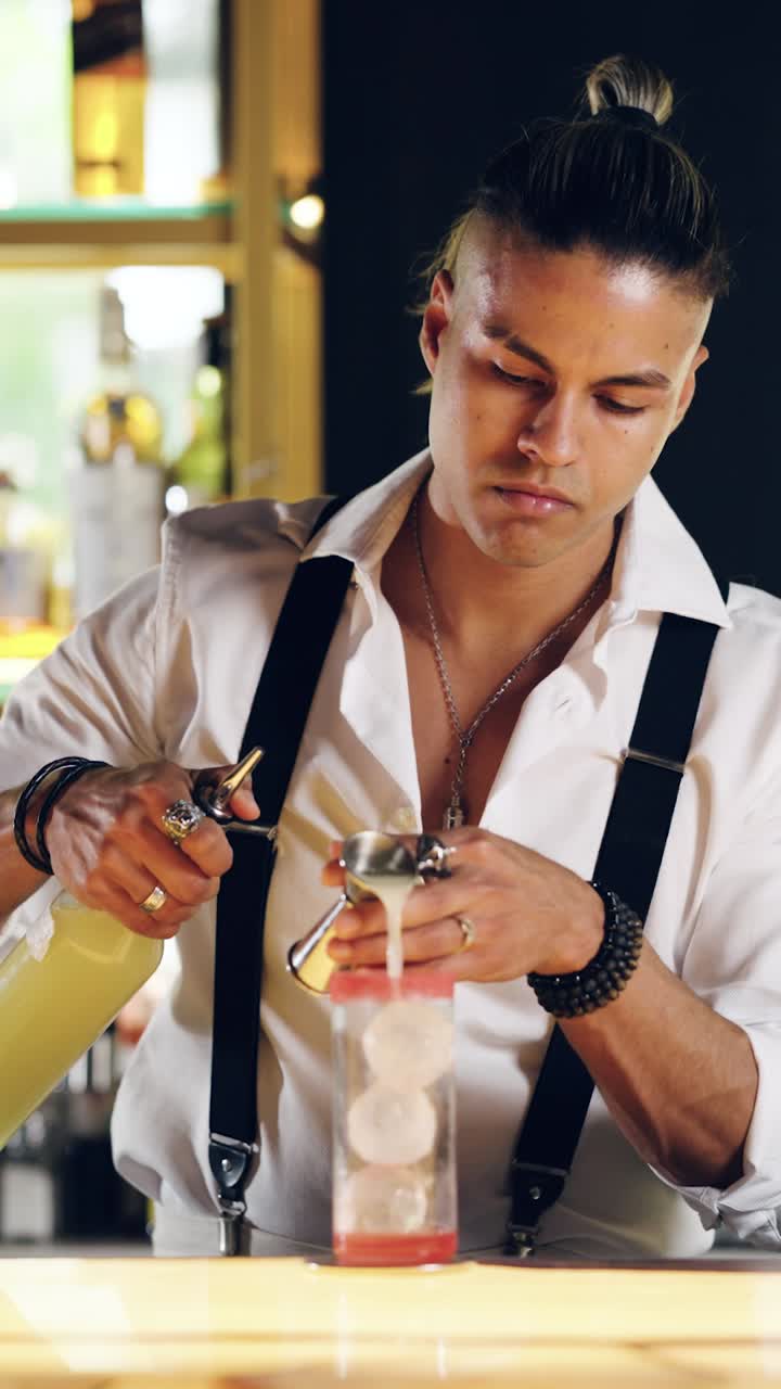 Professioneller Barkeeper gießt Zutaten für einen Cocktail ein