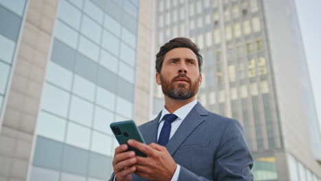 financial manager browsing app looking smartphone screen on street close up.