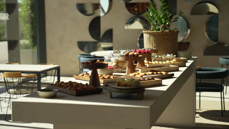 pastry table at a hotel brunch with glamorous cakes and croissants beautifully lit by sun