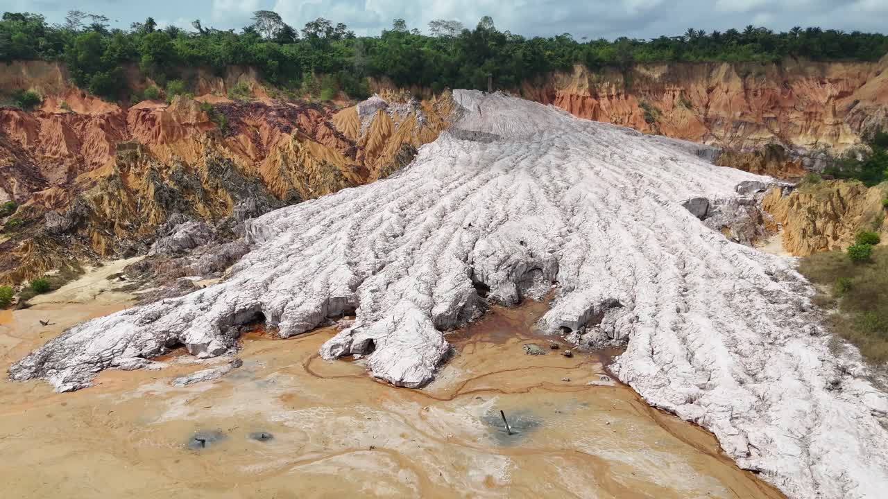 vista aerea mozzafiato da un'angolazione elevata di un enorme ghiacciaio di sale bianco che scorre attraverso una cava rossastra e accidentata nel Congo, in Africa, che mette in mostra texture geologiche uniche