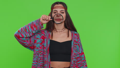 woman holding magnifier glass loupe on teeth looking at camera showing funny smiling face mouth