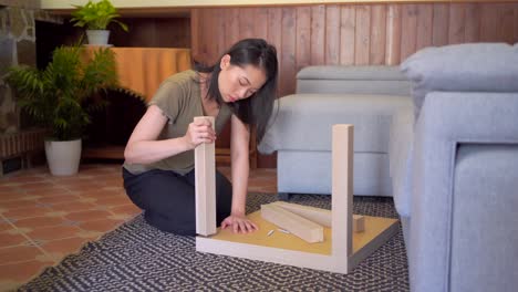 asian woman assembling table in living room