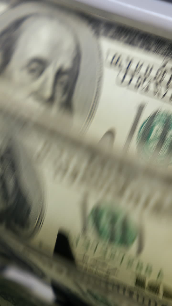 Portrait of President Benjamin Franklin for 100 American dollars cash money. Money counting equipment for paper money calculation. Automatic mechanism for bank financial operations. Vertical video