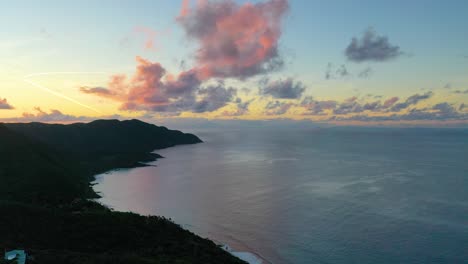 serene aerial footage shows a radiant dawn sky glowing over st. croix’s coast, where a scenic peninsula meets calm waters shimmering softly beneath vibrant clouds