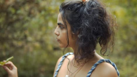 fotografía cinematográfica en cámara lenta de un modelo tocando una planta en la selva tropical de goa, india con cabello negro, slomo