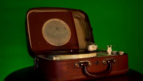 Gramophone-with-music-disc-on-green-background-rotates-slowly,-retro-voice-recording