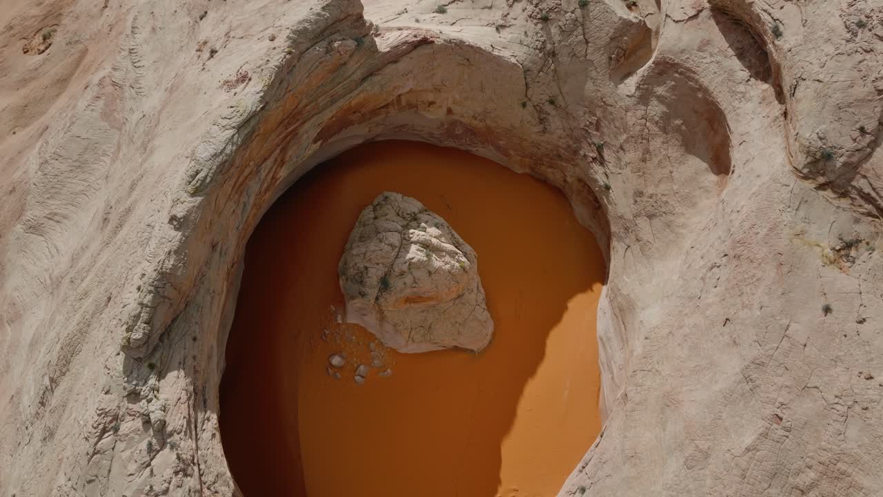 Cosmic Ashtray, bacino circolare di arenaria che contiene sabbia arancione nel paesaggio desertico dello Utah, ripresa da drone.